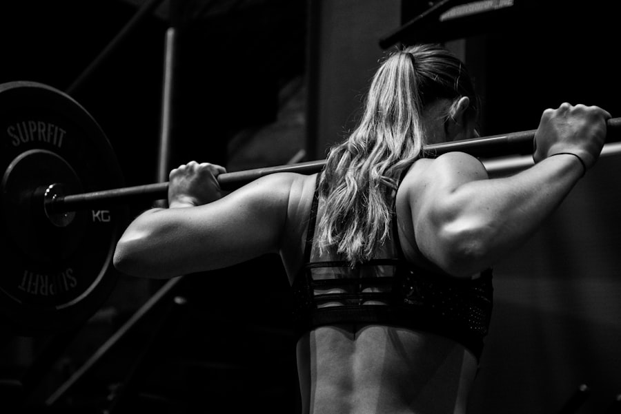 Athlete under a barbell in a dark gym